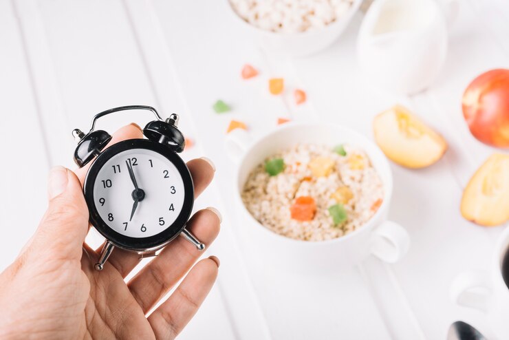 person hand holding alarm clock